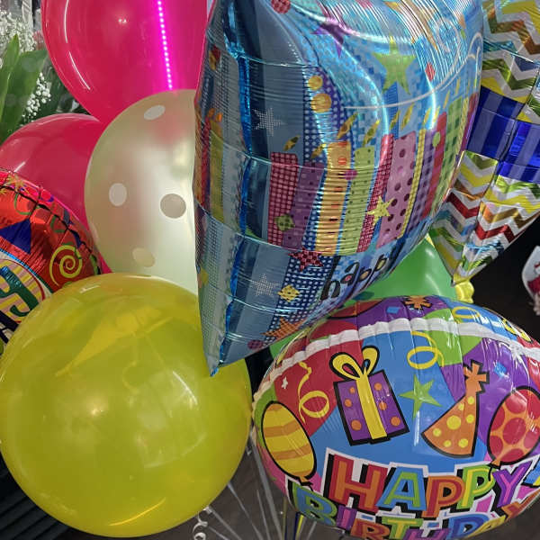 Cluster of colorful birthday balloons, including a "Happy Birthday" balloon