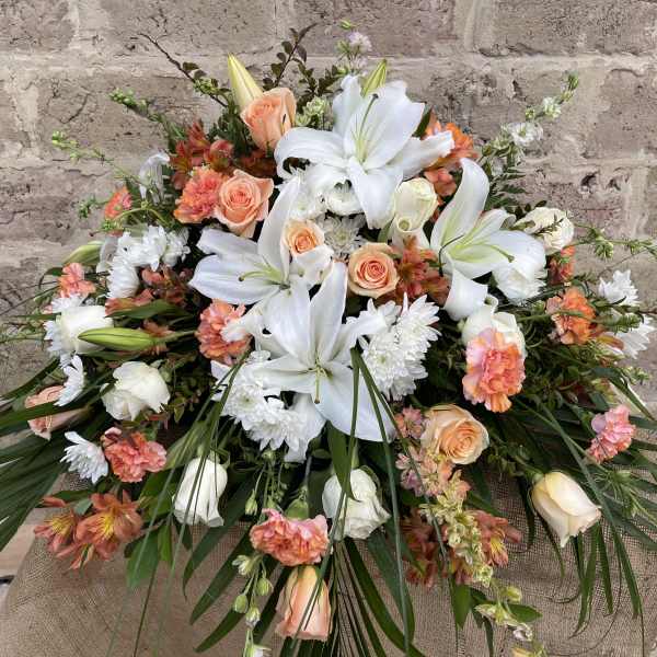 Large bouquet of white lilies, peach roses, and orange carnations