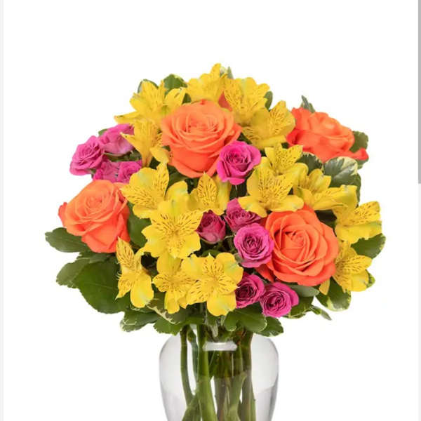 Bouquet of orange and pink roses with yellow flowers in a clear glass vase