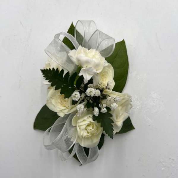 White rose corsage with silver ribbon and green leaves