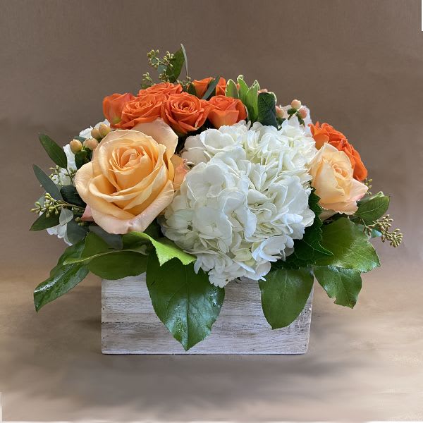 Orange and white roses with white hydrangea in a wooden box