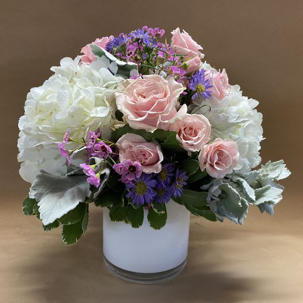 Pink roses and white hydrangeas in a white vase