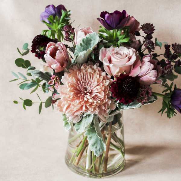 Bouquet of pink and purple flowers in a clear glass vase