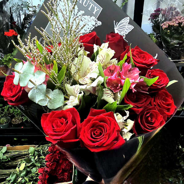 Bouquet of red roses and white alstroemeria in black wrap