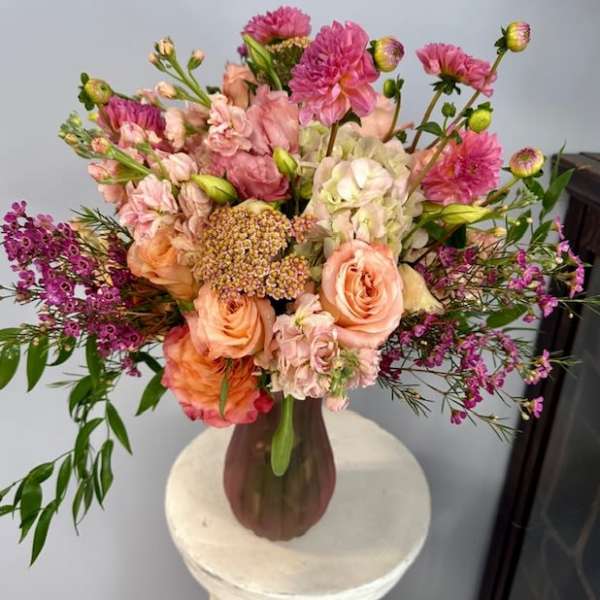 Bouquet of peach and pink flowers in a brown vase
