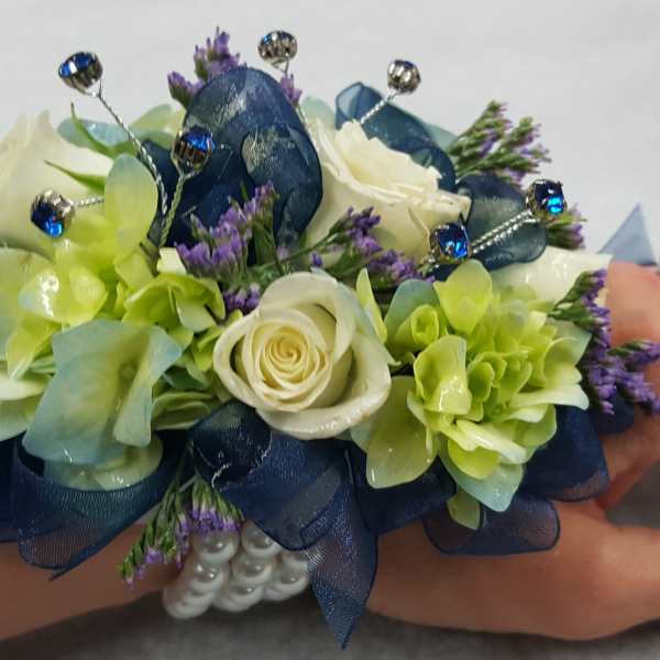Blue and green wrist corsage with white roses and jeweled accents