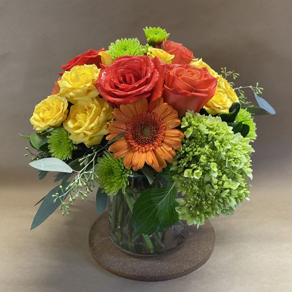 Bouquet of red, yellow, and orange flowers in a glass vase