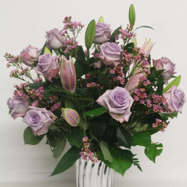 Lavender roses and pink lilies in a clear glass vase