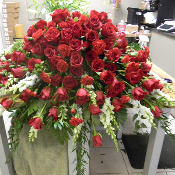 Large arrangement of red roses with white accents on a table