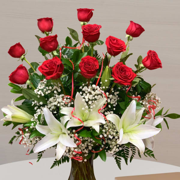 Red roses and white lilies arranged in a glass vase