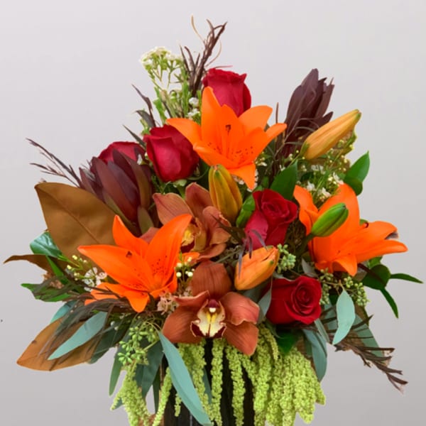 Bouquet of orange lilies and red roses in a black vase