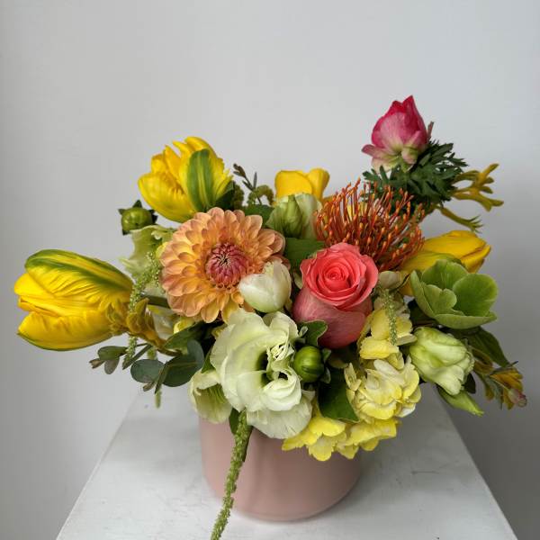 Mixed bouquet in a pink vase with yellow, white, and pink blooms