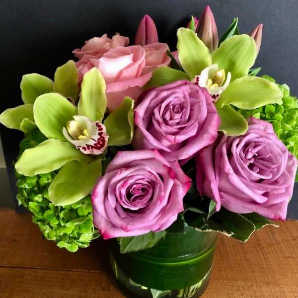Pink roses and green orchids in a glass vase