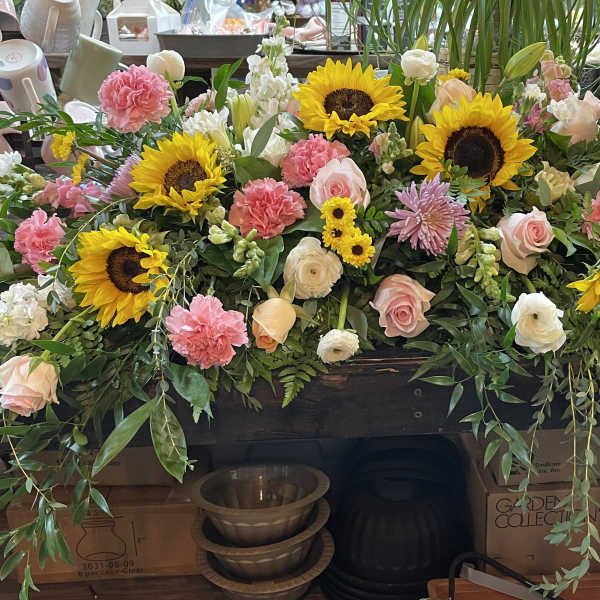 Large floral arrangement with sunflowers, pink roses, and carnations