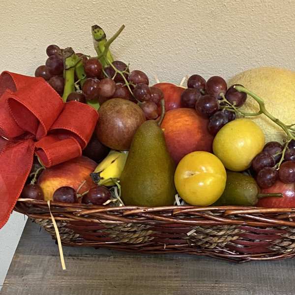 Fruit basket with grapes, pears, apples, and a red ribbon bow