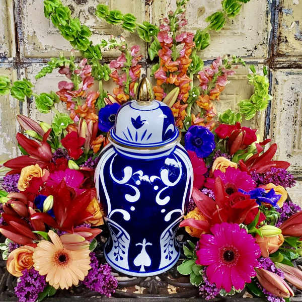 Colorful floral arrangement around a blue-and-white ceramic urn