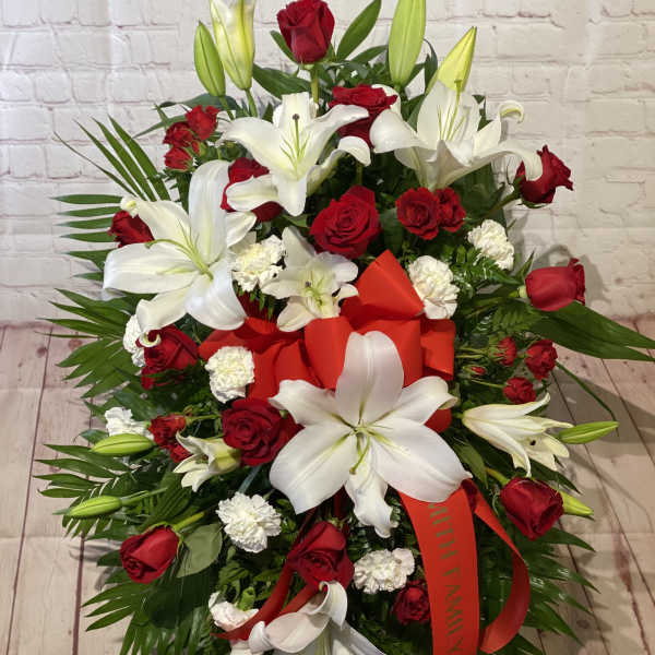 Red roses and white lilies arranged with a red ribbon