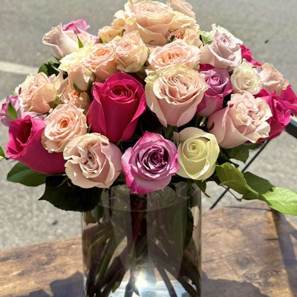 Bouquet of pink and peach roses in a clear glass vase