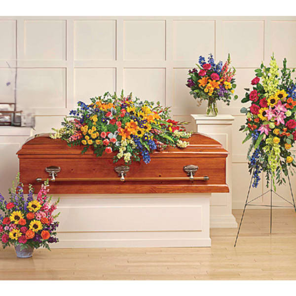 Colorful funeral casket spray with matching standing arrangements