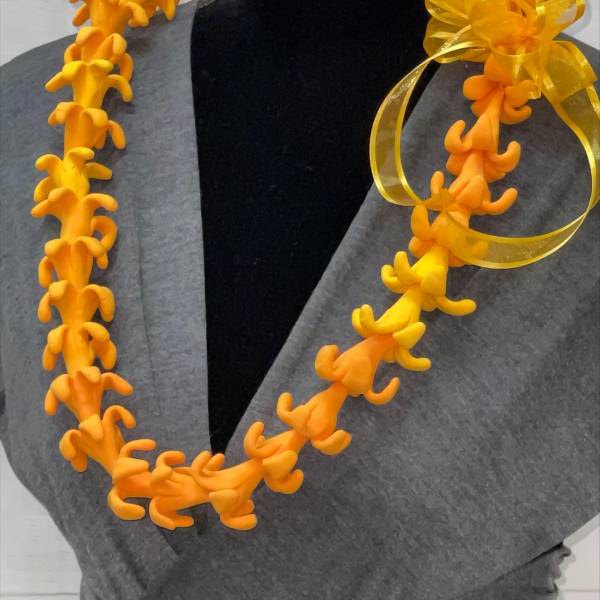 Bright orange artificial flower lei with a yellow ribbon bow on a black mannequin.