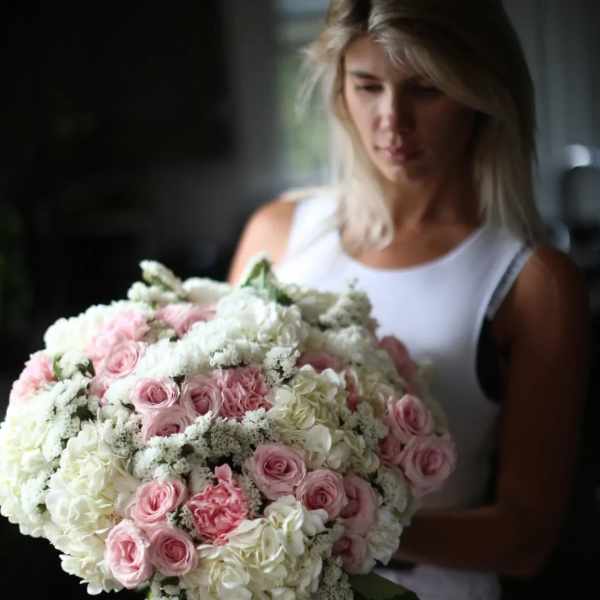 Woman holding a large bouquet of pink and white flowers