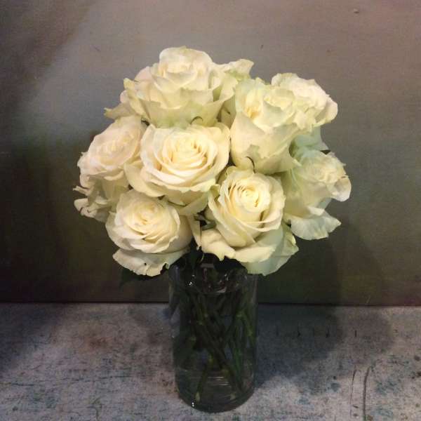 White roses arranged in a clear glass vase