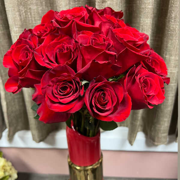 Bouquet of red roses in a tall red and gold vase