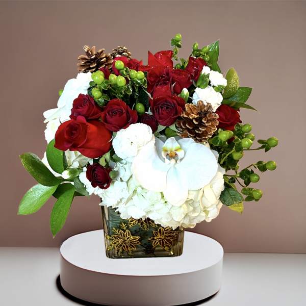 Red roses and white orchids in a square glass vase