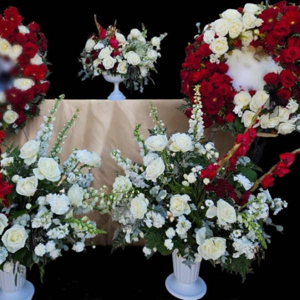 White and red rose funeral wreaths and arrangements on stands
