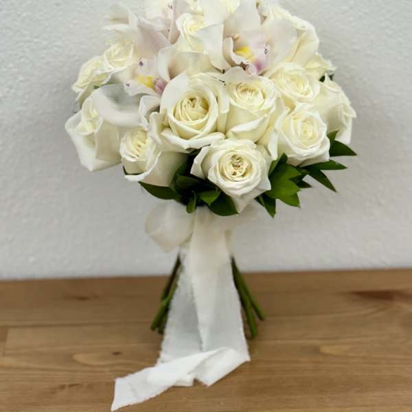 White rose and orchid bouquet with a white ribbon wrap