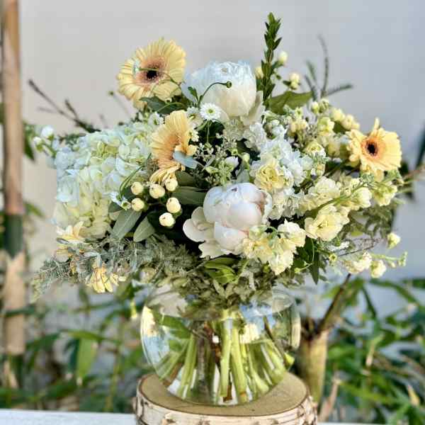 Bouquet of pale yellow and white flowers in a clear glass vase