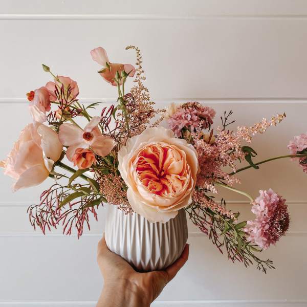 Peach and pink floral arrangement in a white vase