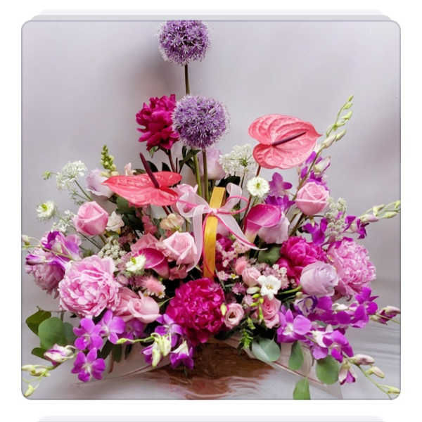 Pink and purple floral arrangement with orchids and roses