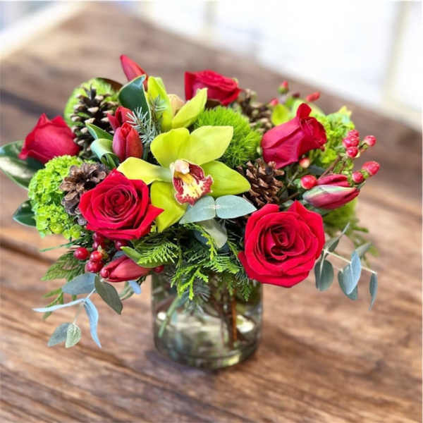 Red roses and green orchids in a glass vase