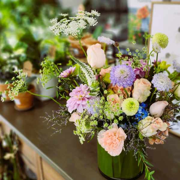 Pastel mixed flower arrangement in a green vase