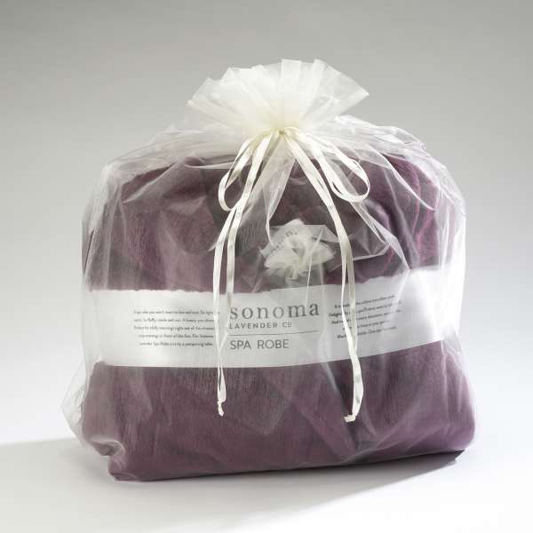 Purple spa robe packaged in a sheer white gift bag tied with ribbon