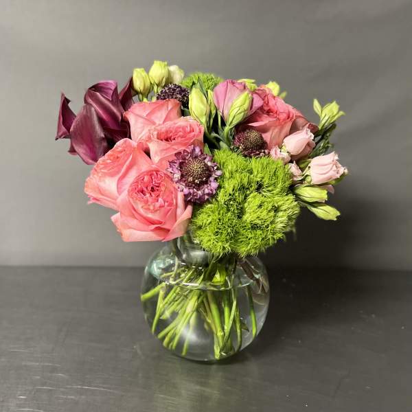 Pink and burgundy bouquet in a clear glass vase