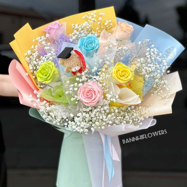 Colorful bouquet with roses, baby’s breath, and a small teddy bear