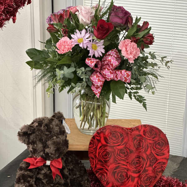Mixed bouquet in a glass vase with a teddy bear and heart-shaped gift box