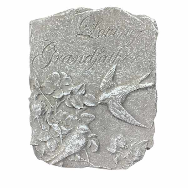 Gray memorial plaque with birds and flowers