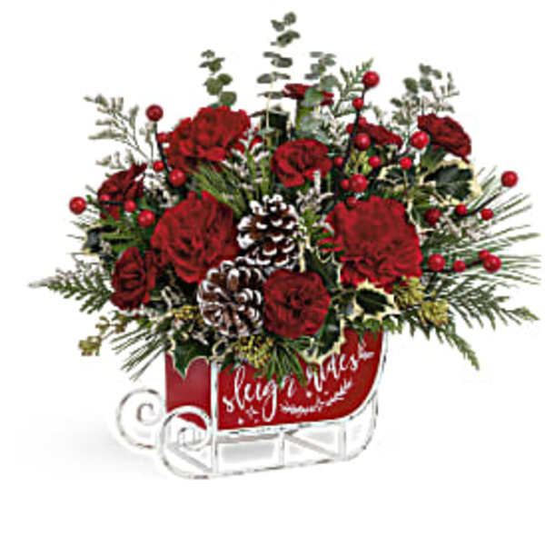 Red floral arrangement in a sleigh-shaped container with pinecones