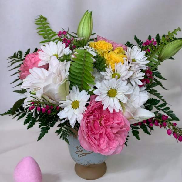 Pink and white flower arrangement with daisies and roses in a vase