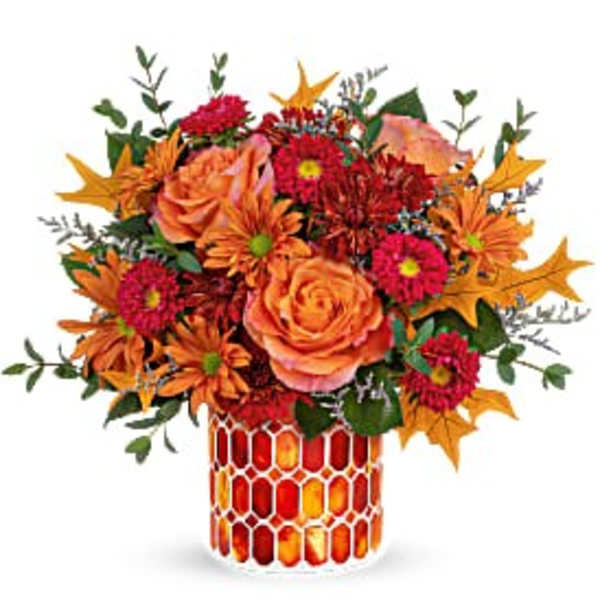 Orange and red floral arrangement in a patterned vase
