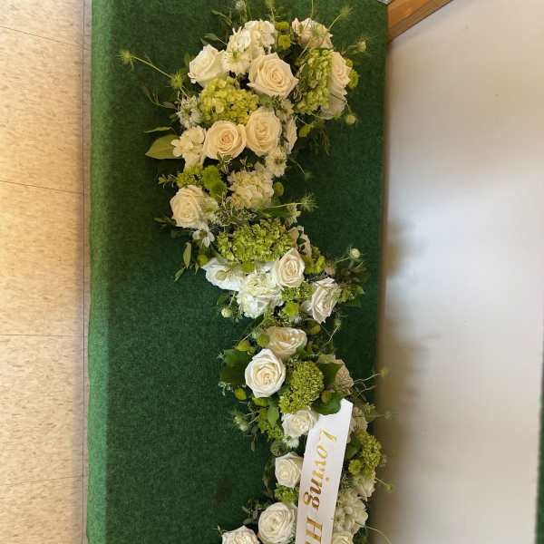 White rose floral arrangement with a ribbon reading Loving Husband