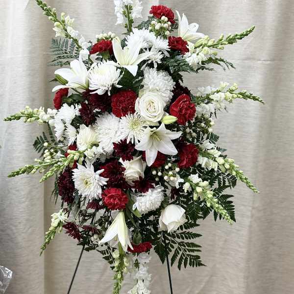 Tall standing floral spray with white lilies, chrysanthemums, and red carnations
