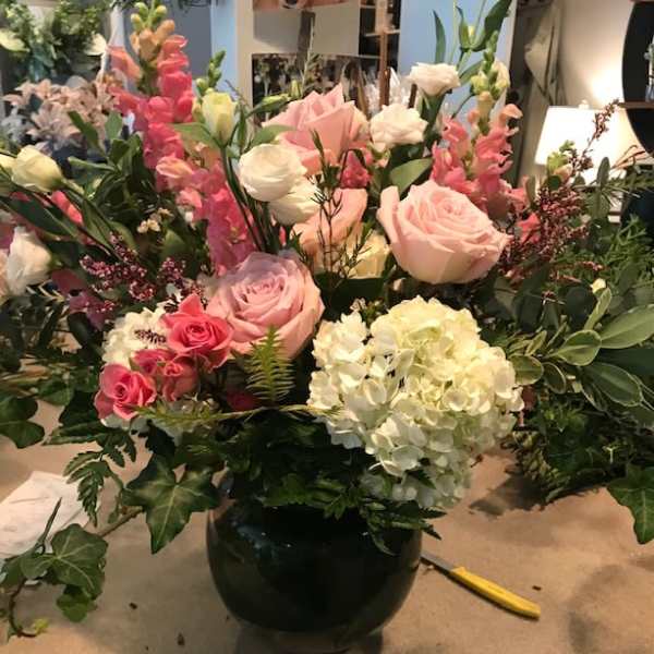 Mixed pink and white flower arrangement in a black vase