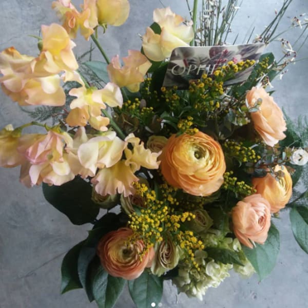 Bouquet of peach flowers with orange ranunculus and yellow accents