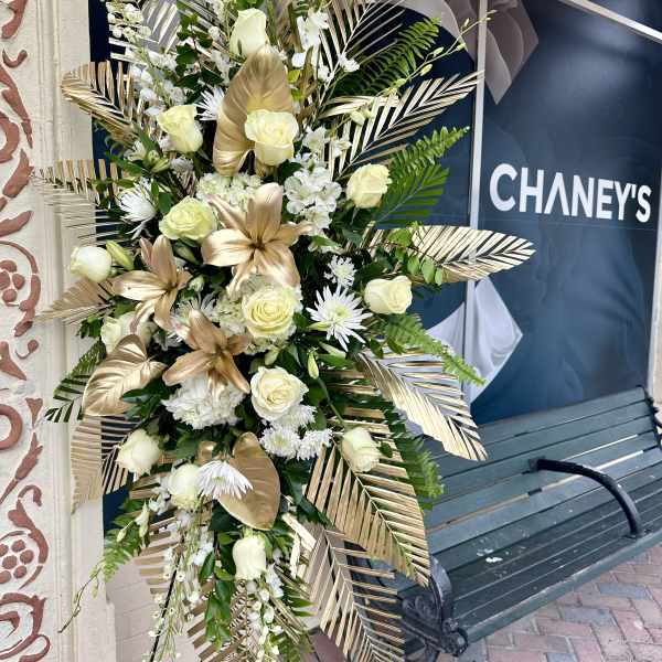 Tall white and gold floral standing spray with roses and lilies