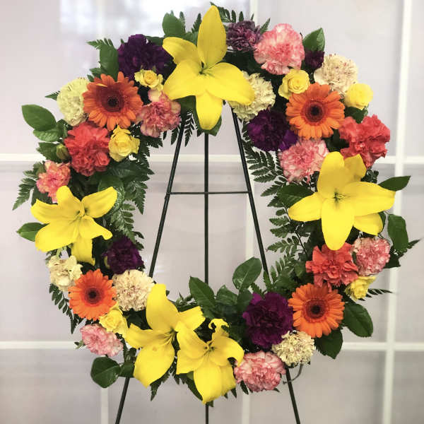 Heart-shaped floral wreath with yellow lilies, gerberas, and carnations