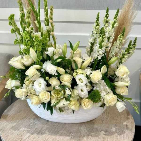 Large white floral arrangement in a low white container